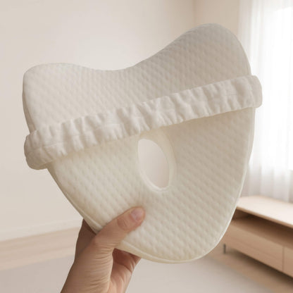 Hand holding the EverComfort ComfortCurve knee pillow, showing its contoured shape and size